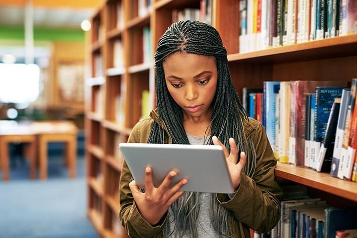 Student holding an iPad.